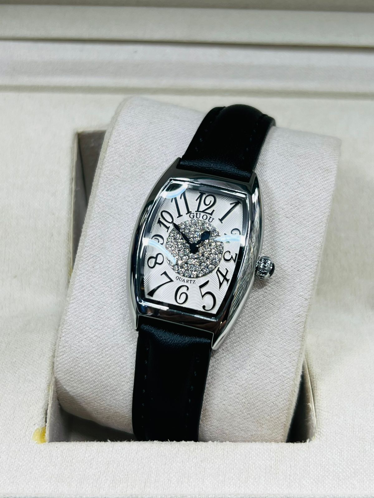 This is a GUOU quartz watch with a black dial, diamond accents, and a black strap.
